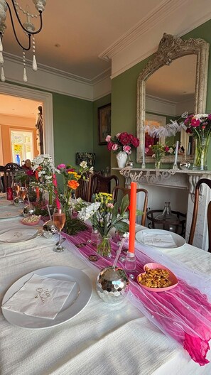 Taula de dinar preparada amb plats, vasos i un centre de taula decoratiu.