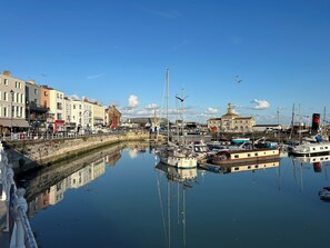 A marina with boats docked, a waterfront promenade, and buildings with historical architecture. - Ramsgate Retreats | Latimer House, families, big birthdays, golf, parking, 6-14 (ramsgate)