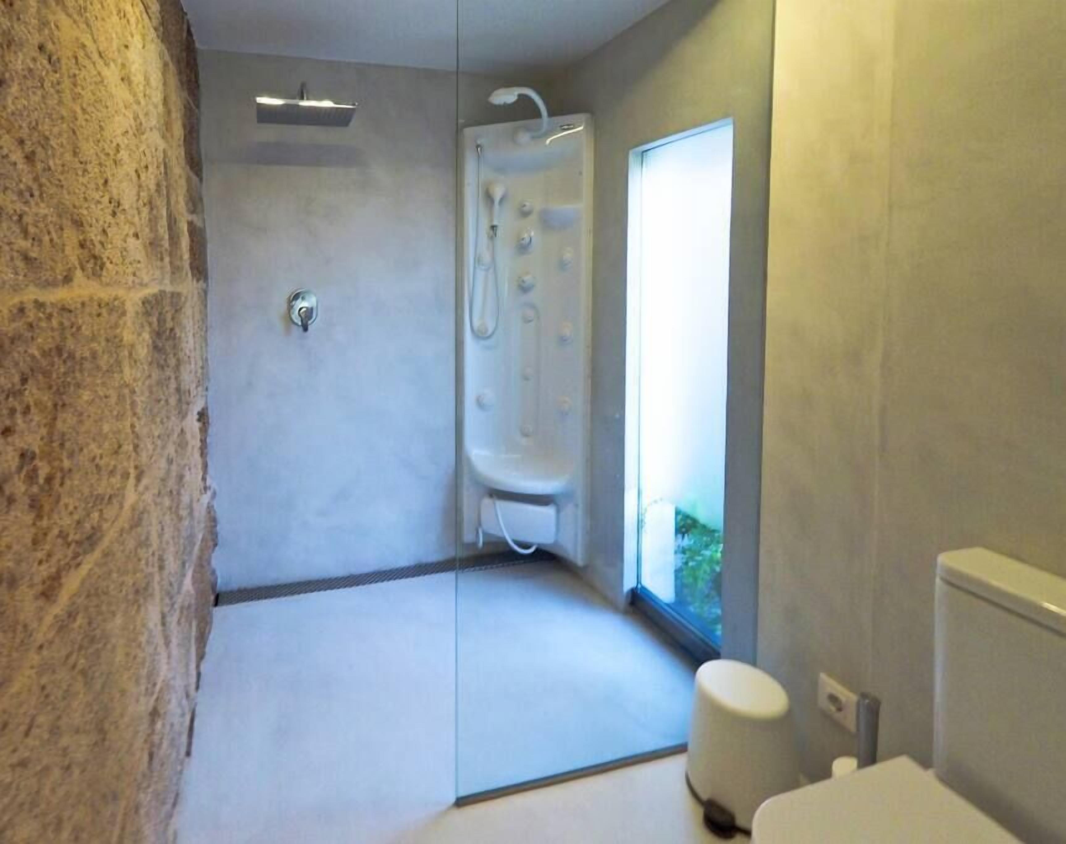 Ein modernes Badezimmer mit Dusche, Toilette und einem Fenster für Tageslicht.