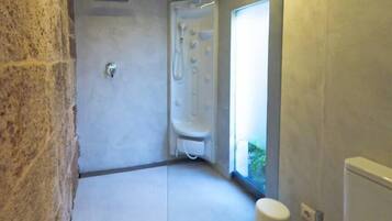 Ein modernes Badezimmer mit Dusche, Toilette und einem Fenster für Tageslicht.