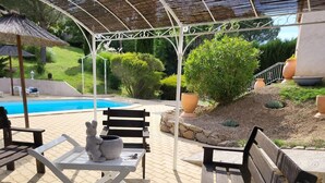 A covered outdoor seating area with a pool, benches, and a table with a rabbit sculpture. - 15mn Cannes, Fréjus, Gîte les Mimosas 2à4pers animals contact the owner (Montauroux)