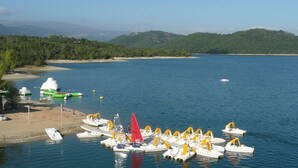 A marina with several small boats docked, a sandy beach, and a forested hill in the background. - 15mn Cannes, Fréjus, Gîte les Mimosas 2à4pers animals contact the owner (Montauroux)