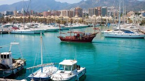 A marina with various boats docked, a cityscape in the background, and mountains. - Beachside villa with panoramic sea views (Benalm���dena-Costa)