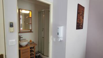 Un baño con lavamanos, espejo y ducha.