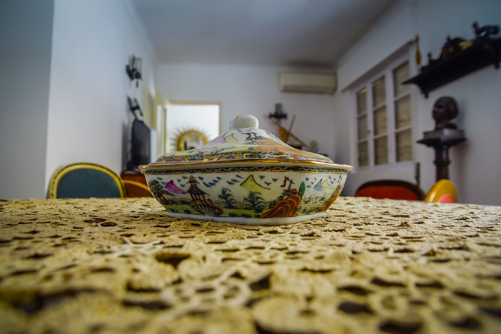 Un bol de ceràmica amb tapa sobre un mantell texturat.