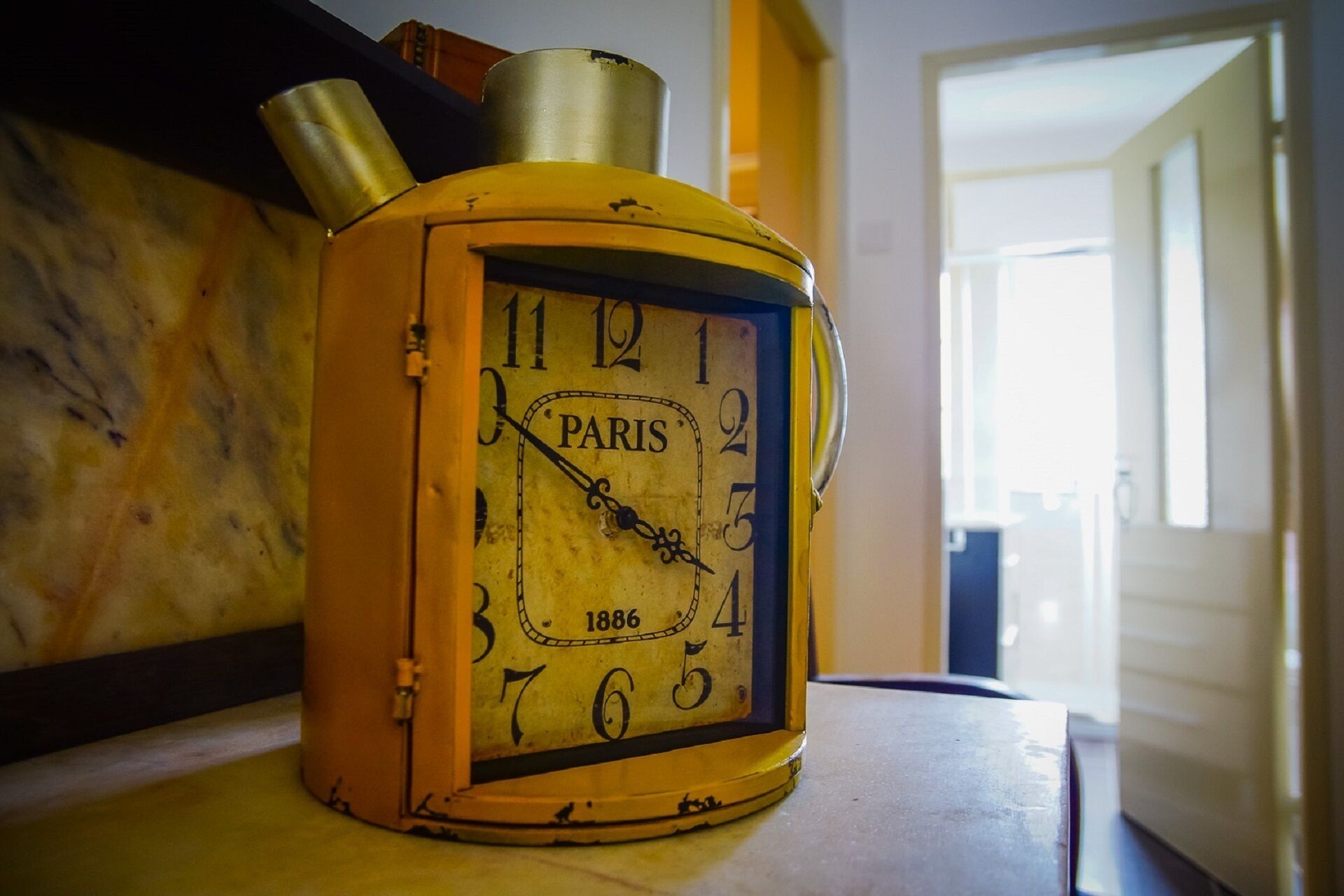 Eine Vintage-Paris-Uhr mit dem Jahr 1886 auf einer Holzoberfläche.