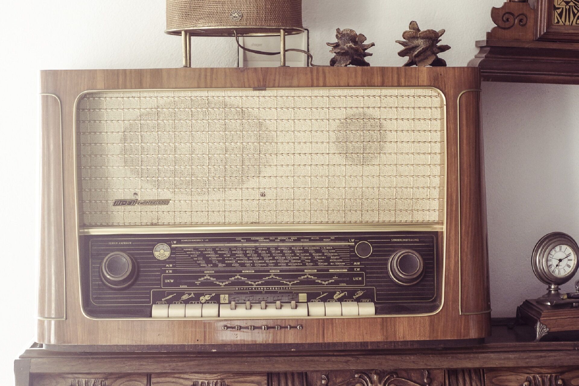 A vintage radio with a wooden cabinet, a tuning dial, and a frequency display.