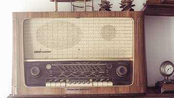 A vintage radio with a wooden cabinet, a tuning dial, and a frequency display.