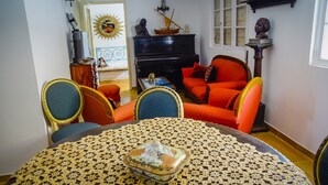 Un comedor con una mesa redonda, sillas y un mantel decorativo.