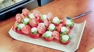 Une assiette d'amuse-gueules à base de tomates et de mozzarella, posée sur une table en bois.