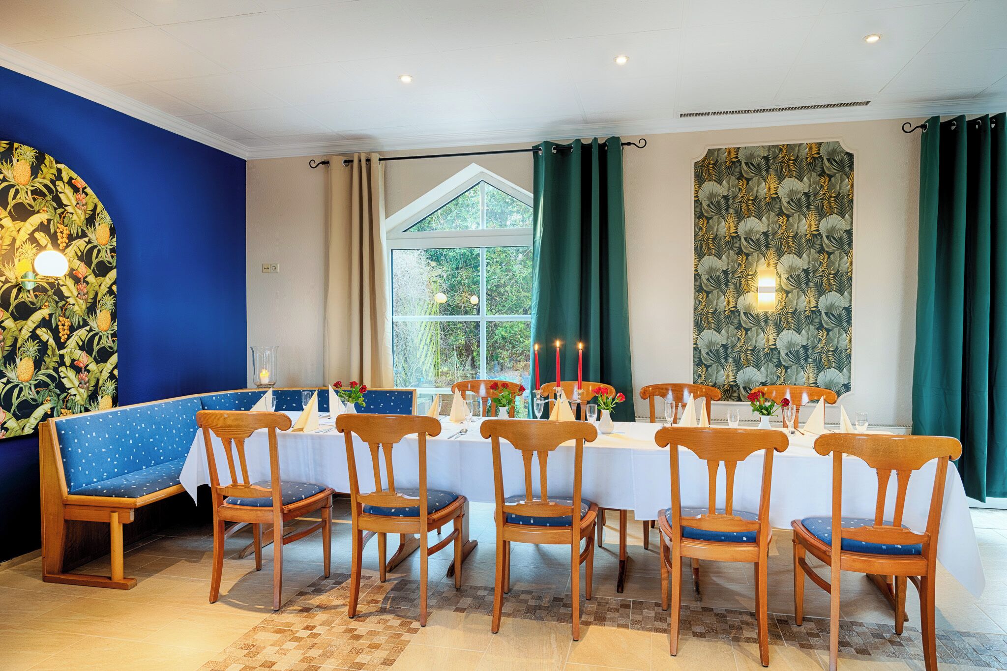 Een eetruimte met een tafel gedekt voor zes personen, omringd door houten stoelen met blauwe kussens.