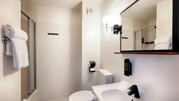 A modern bathroom with a toilet, sink, and shower.