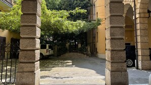 A courtyard with stone columns, a paved path, and a vehicle parked in the background. - Casa Magnolia- Big apartment near the Arena (Verona)