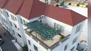 A multi-story building with a rooftop terrace featuring a green roof and outdoor seating. - Perfect Havens at Platinum 5 (Lagos)
