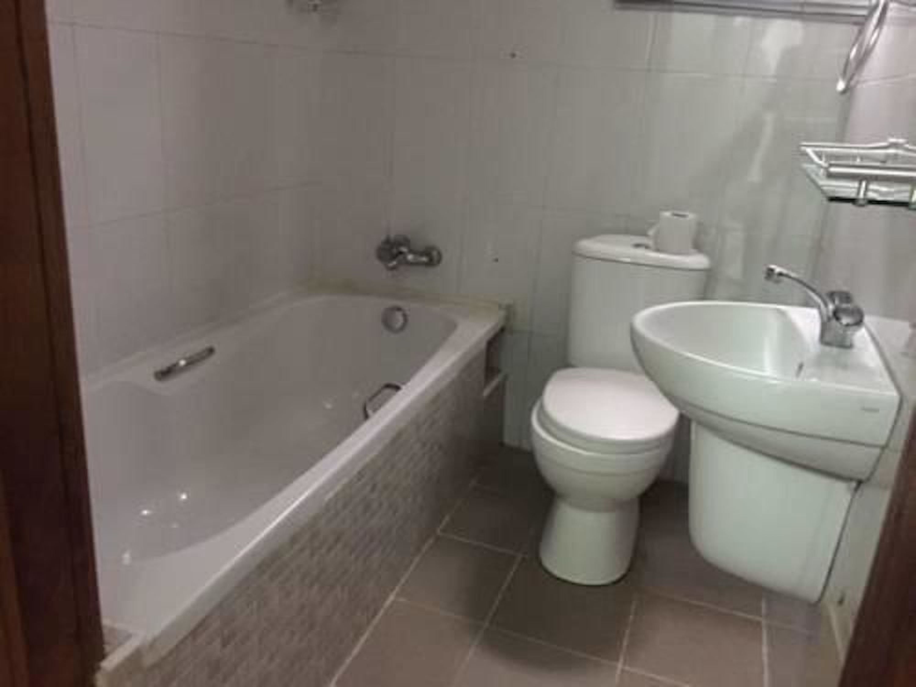 Een badkamer met een bad, toilet en wastafel.