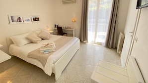 Une chambre d’hôtel avec un lit, un bureau et une télévision.