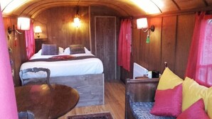 Un interno accogliente con un letto, un tavolo in legno e un divano con cuscini.