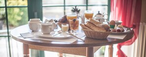 A breakfast table with various breakfast items, including bread, eggs, and beverages. - Auberge du Porche (Blaye)