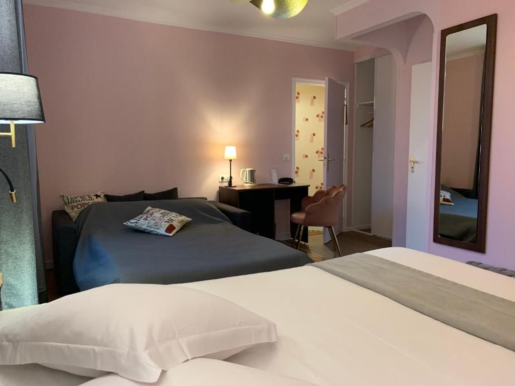 Una habitación de hotel con una cama, un escritorio, una silla y un espejo.