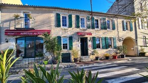 A two-story stone building with a red awning labeled "Hôtel Auberge du Porcien." - Auberge du Porche (Blaye)