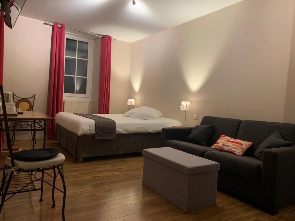 Una stanza con un letto, un divano, un tavolino e una sedia.