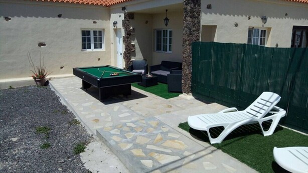 Ein Billardtisch, Sitzgelegenheiten im Freien und eine umzäunte Terrasse.