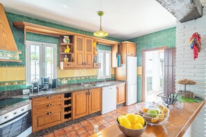 Una cocina con armarios de madera, encimera de granito y un cuenco de fruta.
