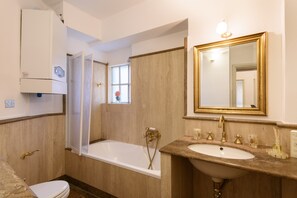 Een bad/douchecombinatie, een haardroger, een bidet, handdoeken