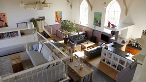 A spacious living area with a staircase, a dining table, and a kitchen area.