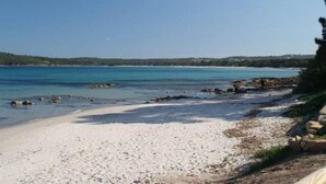A beach with clear water, a sandy shore, and a forested background. - COMFORTABLE CHALET HEATED POOL BEACHES AND RIVER 10 MIN AWAY (Conca)