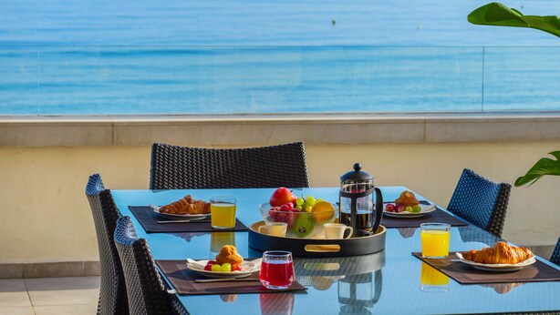 A table with breakfast items, a coffee pot, and a view of the sea. - 405 Luxury 4 Bed Penthouse, Heated 20m Pool-Front Line-Paseo-Bikes-BBQ-Hot Tub (Estepona)
