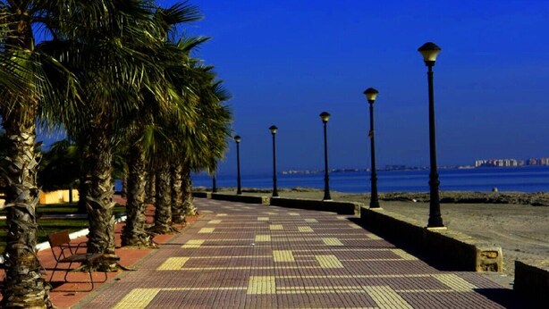 A paved walkway with palm trees and street lamps, leading to a body of water. - Excellent value villa with communal pool, 5minute beach & golf  (Los Alcazares, San Javier)