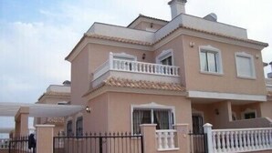 A multi-story residential building with a symmetrical facade, balconies, and a gated entrance. - Excellent value villa with communal pool, 5minute beach & golf  (Los Alcazares, San Javier)
