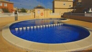 A swimming pool with a clear blue water surface, surrounded by a low beige wall. - Excellent value villa with communal pool, 5minute beach & golf  (Los Alcazares, San Javier)
