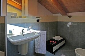 Une salle de bain avec un grand lavabo, une baignoire et des toilettes.