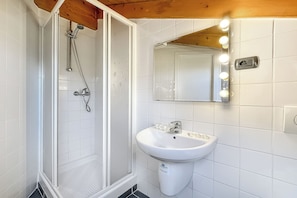 Een bad/douchecombinatie, een haardroger, een bidet, handdoeken