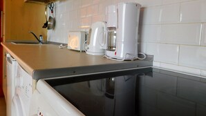 Eine Küche mit Arbeitsplatte, Kaffeemaschine, Toaster und Geschirrspüler.
