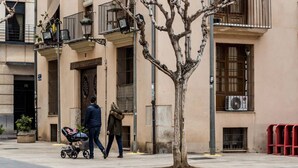 A building with a balcony, a tree, and a stroller.