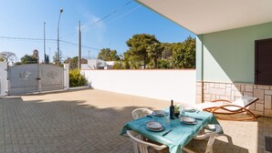 A patio with a table set for dining, chairs, and a view of the surrounding area including a gate and trees. - Entrance, living room, kitchen, 3 spacious rooms, 4p bedroom, 2 bathrooms, garden, place car (Tuglie)