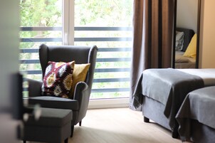 Una habitación con cama, una silla y ventana con persianas.