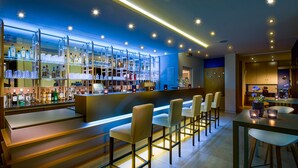 A bar area with a counter, shelves of bottles, and seating. - Kristallhotel Fettehenne (Leverkusen)