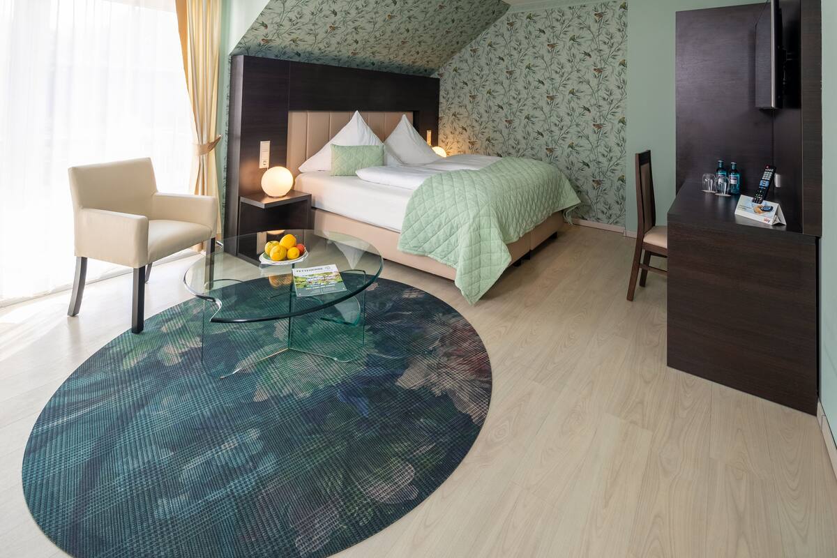 A modern bedroom with a bed, bedside table, chair, and a round coffee table.