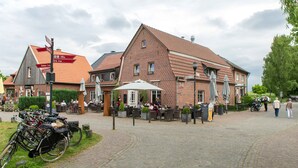 A brick building with outdoor seating and bicycles parked nearby. - Hotel am Tiergarten (Raesfeld)