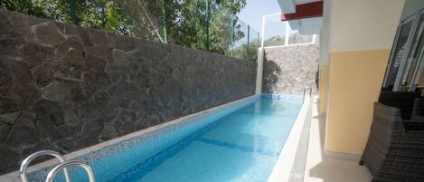 Una piscina al aire libre, tumbonas