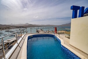 Una piscina al aire libre, sillones reclinables de piscina