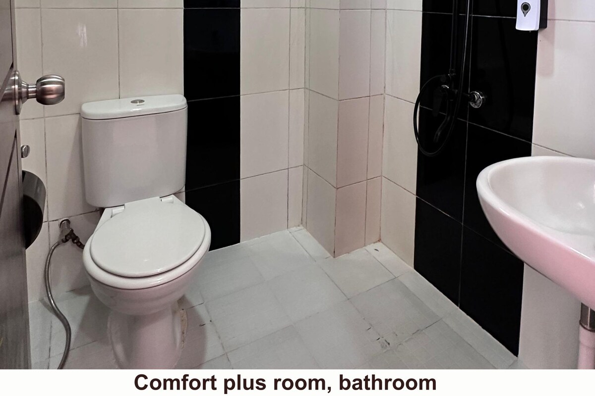 A bathroom with a toilet, sink, and tiled walls.