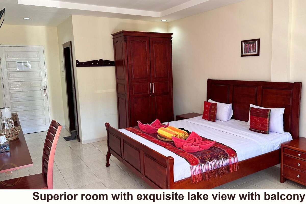 A superior room with a bed, a wardrobe, a bedside table, and a view of a balcony.