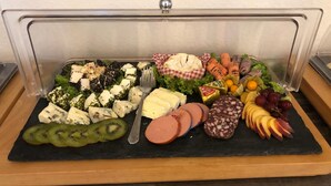 A charcuterie board with various cheeses, meats, fruits, and vegetables. - Hotel Am Stadtpark (Papenburg)