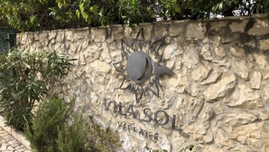 A stone wall with a metal sign reading "Villasol" and "Vega de Sol." - Luxury, spacious, two bedroom apartment on the Vill Sol Golf & Spa Resort (Quarteria)