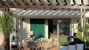 A modern house with a patio area, outdoor seating, and potted plants. - Luxury, spacious, two bedroom apartment on the Vill Sol Golf & Spa Resort (Quarteria)
